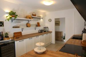a kitchen with white cabinets and a wooden counter top at Dalmatian stone house with swimming pool near Supetar in Supetar