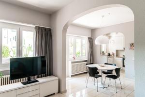 sala de estar con TV y mesa con sillas en Agave Apartment by Quokka 360 - flat with large terrace in Lugano, en Viganello