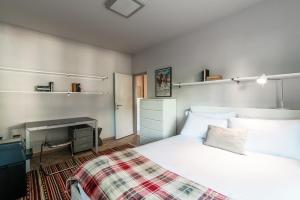 1 dormitorio con cama blanca y chimenea en Agave Apartment by Quokka 360 - flat with large terrace in Lugano, en Viganello