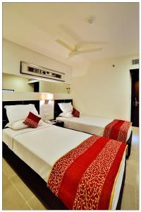 two beds in a hotel room with two beds sidx sidx sidx at SVN GRAND in Kākināda +21 photos