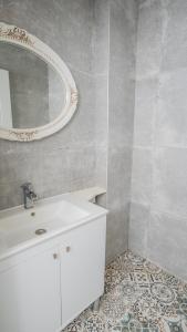 uma casa de banho com um lavatório branco e um espelho. em Salonika Suites em Oludeniz