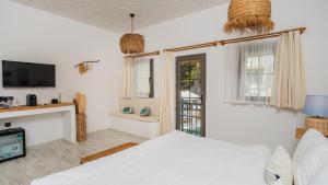 a bedroom with a bed and a tv and a window at Salonika Suites in Oludeniz