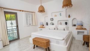 ein weißes Schlafzimmer mit einem Bett und einem Fenster in der Unterkunft Salonika Suites in Oludeniz
