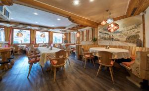 a restaurant with tables and chairs in a room at Apart-Hotel Forellenhof in Saalbach Hinterglemm