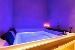 a purple bathroom with a tub with a bottle of wine at Al Castello Luxury B&B in Reggio Calabria