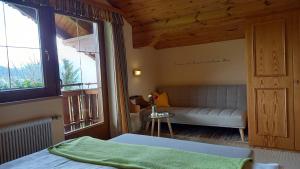 a bedroom with a bed and a couch and windows at Pension Felsenheim in Ramsau am Dachstein