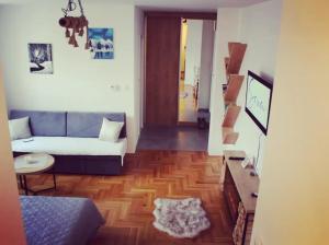 a living room with a couch and a wooden floor at Apartman Srna Pale in Pale