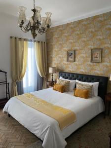 una camera da letto con un grande letto bianco e carta da parati gialla di Pátio da Villa - Coruche Boutique Guest House a Coruche