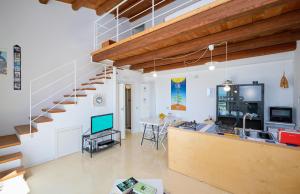 a living room with a staircase and a television at Petrantica in Marina di Ragusa