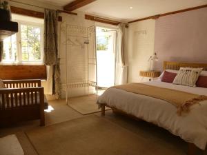 a bedroom with a bed and a large window at Priory Cottage Bodmin in Bodmin