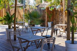 a patio with tables and chairs and a fence at Noemys ARLES in Arles