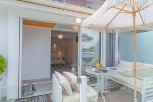 een balkon met een tafel en stoelen en uitzicht op de oceaan bij Tango Apartment On The Beach in Paleokastritsa