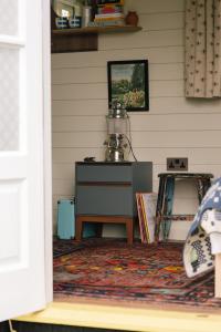 Zimmer mit einem Tisch und einem Teppich an der Wand in der Unterkunft Beekeeper's Hut - Hawarden Estate in Hawarden