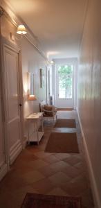 a hallway with a door and a living room with rugs at Domaine et Manoir du Picaud in Monestier
