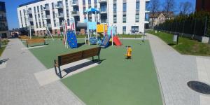 park z placem zabaw z ławką i zjeżdżalniami w obiekcie Apartament Wierzyca w mieście Pelplin