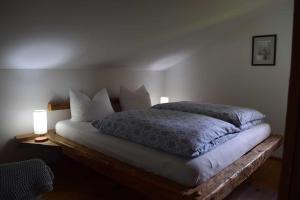 a bedroom with a large bed with two lamps at Birken Chalet in Falkenfels