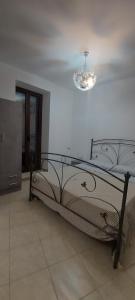 Cama en habitación con lámpara de araña en LA CASA DI NONNA GIOVANNA, en Fiumedinisi