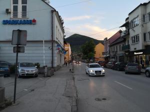 a street with cars driving down a city street at Apartment Mirror in Visoko