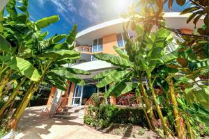 a building with palm trees in front of it at Copacabana Hotel in Ravda