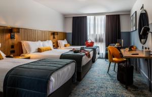 a hotel room with two beds and a desk at Dublin Skylon Hotel in Dublin