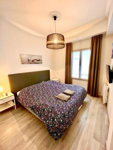 1 dormitorio con 1 cama con manta morada en Ma Location Sablaise - Appart' Grande Plage, en Les Sables-dʼOlonne