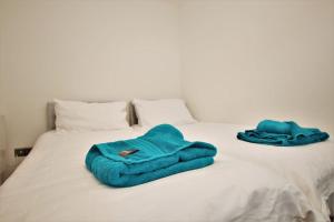 two towels are sitting on a white bed at St James Apartment in Ilfracombe