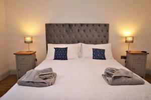 a bedroom with a large white bed with two lamps at St James Apartment in Ilfracombe