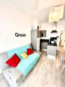 een woonkamer met een bank en een keuken bij Ma Location Sablaise - Appart' Grande Plage in Les Sables-dʼOlonne