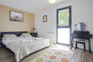 um quarto com uma cama, um espelho e uma janela em Villa Miarritze - Welkeys em Biarritz