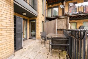 a patio with a table and chairs and a balcony at Prince William Apartment in London