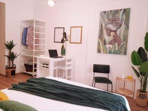 Un dormitorio con una cama y un escritorio con una computadora portátil. en Room Lui, en Rijeka