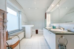 biała łazienka z 2 umywalkami i dużym oknem w obiekcie Guesthouse in the heart of the flemish ardennes w mieście Zwalm