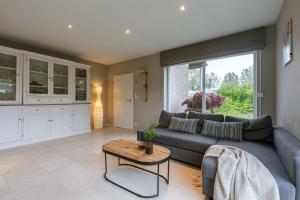 a living room with a couch and a table at Huswell - Guesthouse in the heart of the flemish ardennes in Zwalm