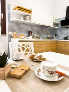uma cozinha com uma mesa com uma chávena e pratos de comida em B&B BABBU MEU em Bosa