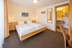 1 dormitorio con 1 cama blanca grande. en Aktiv Hotel & Spa Hannigalp en Grächen