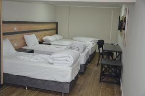 a row of beds in a room with a desk at Marka Hotel in Antalya