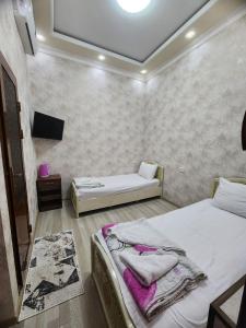 um quarto com uma cama e uma televisão em Yusuf Gold House em Samarkand