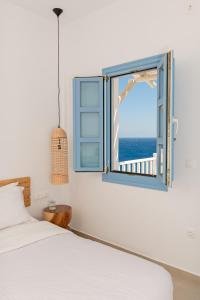 1 dormitorio con cama y ventana en Ihthioessa Boutique Hotel, en Astipalea