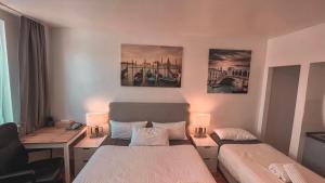 um quarto com 2 camas, uma secretária e 2 candeeiros. em Apartments am Rheingarten em Colônia