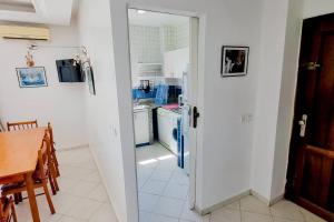 una cucina con porta aperta su una cucina con tavolo di Élégant appartement 3 chambres a Rabat