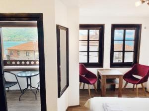 a room with two windows and a table and chairs at Villa Sapkar Lake View in Ohrid