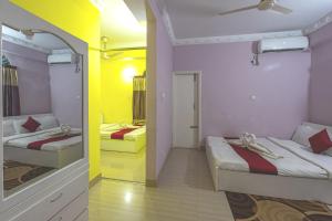 two beds in a room with yellow and white at Grand Selim Resort & Tour – GSRT in Sreemangal