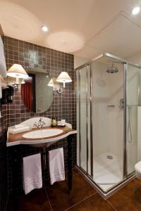 a bathroom with a sink and a shower at Hotel Fontaines du Luxembourg in Paris