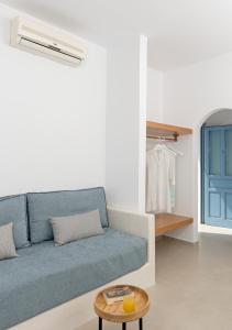 a living room with a blue couch and a table at Ihthioessa Boutique Hotel in Astypalaia