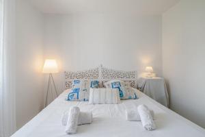1 dormitorio con 1 cama blanca y 2 lámparas en Villa Saint-Georges - Welkeys, en Saint-Georges-dʼOléron