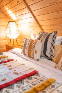 łóżko z poduszkami i lampką na drewnianym suficie w obiekcie Magurska Ostoja w mieście Jasło