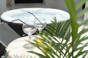 two wine glasses sitting on a table with a bath tub at Brothers House in Arrecife +19 photos