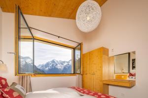 a bedroom with a window with a view of mountains at Aktiv Hotel & Spa Hannigalp in Grächen