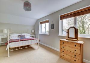 een slaapkamer met een bed, een dressoir en een spiegel bij Tiscott Cottage in Poughill