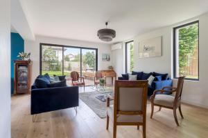 uma sala de estar com um sofá azul e cadeiras em Familial villa with pool - Tassin-la-Demi-Lune - Welkeys em Tassin-la-Demi-Lune
